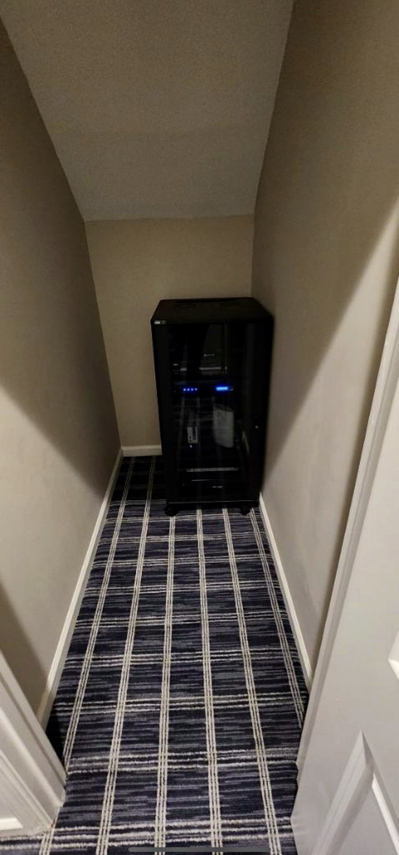 AV rack tucked into a stair-closet nook