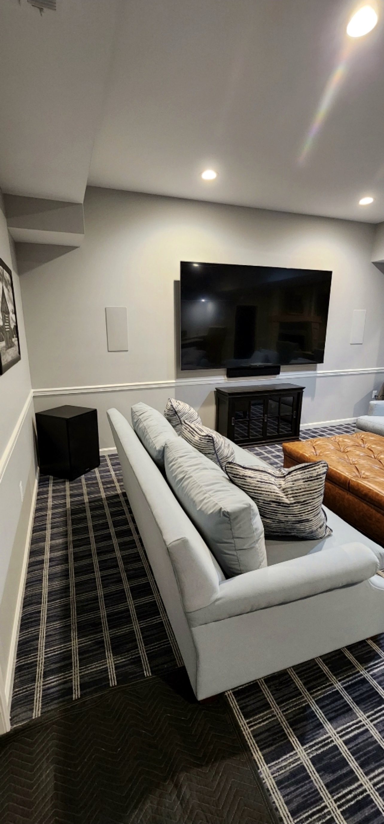 Basement lounge with sectional and mounted TV