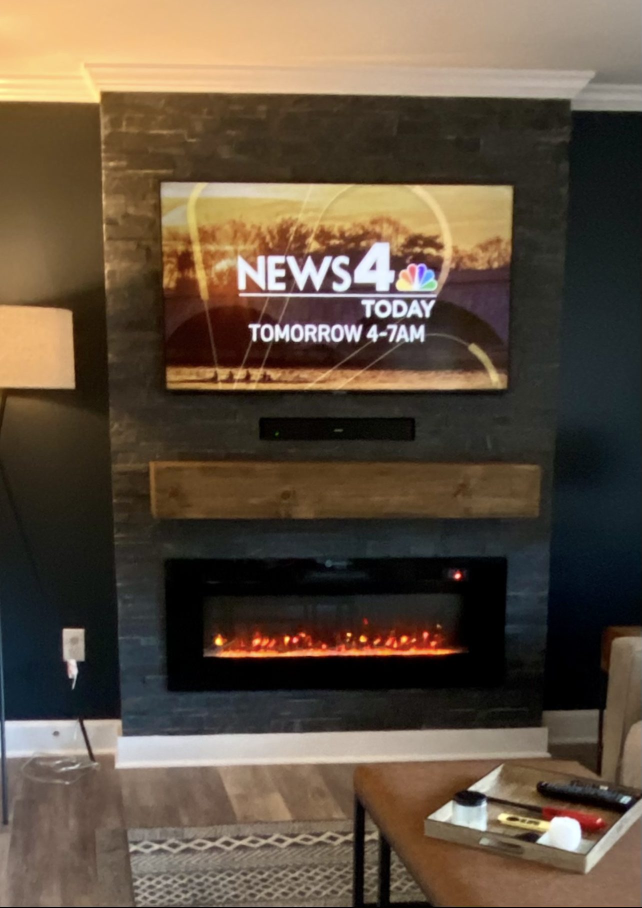 TV over linear fireplace on stone slat wall